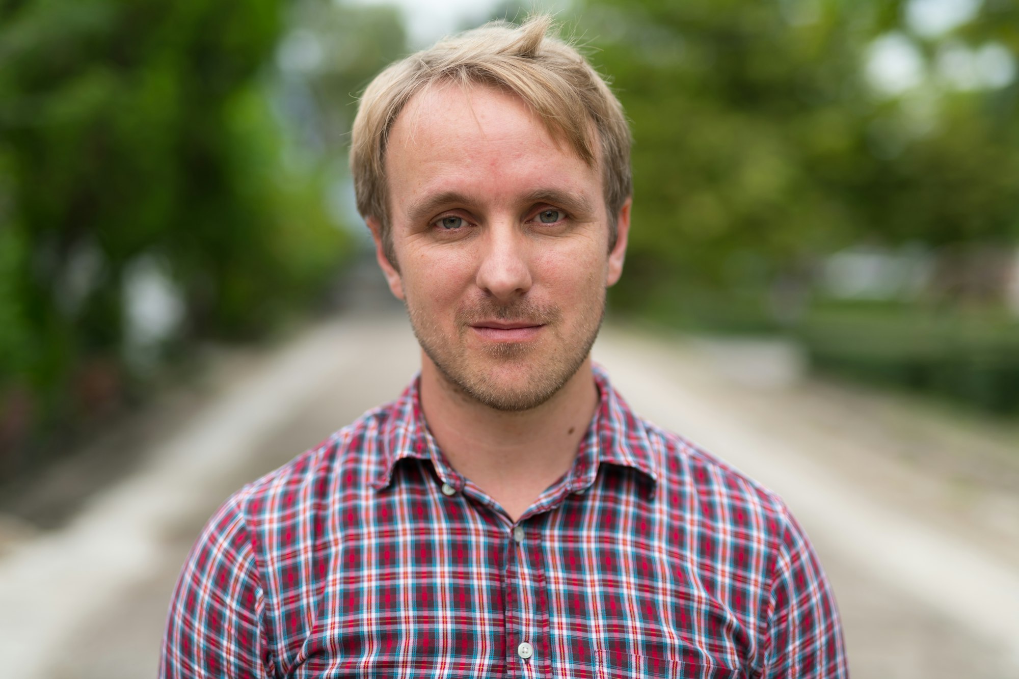 Head shot of man with blonde hair outdoors